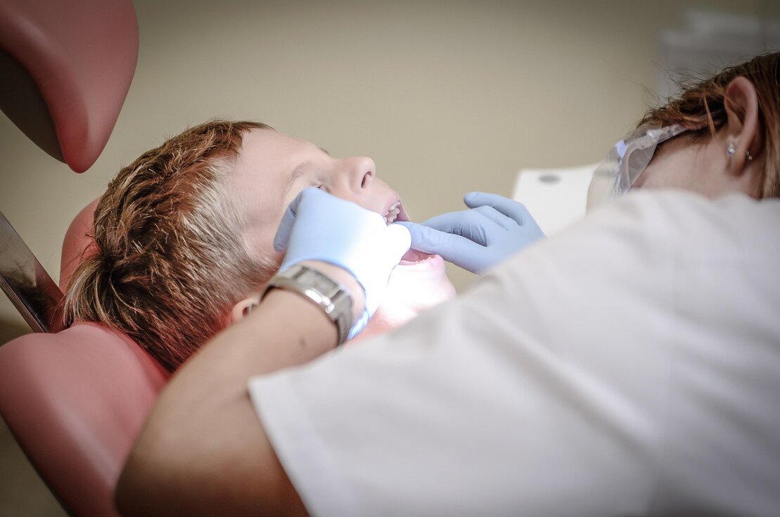 Bambino sorridente durante la visita dal dentista pediatrico
